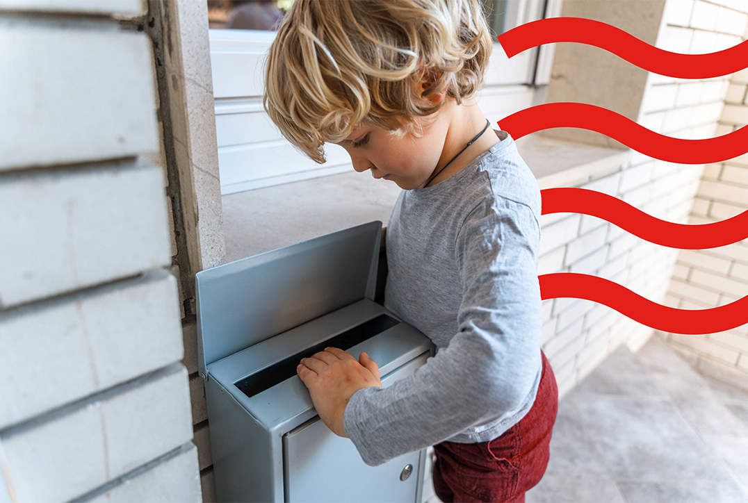 A little child is looking into the mailbox