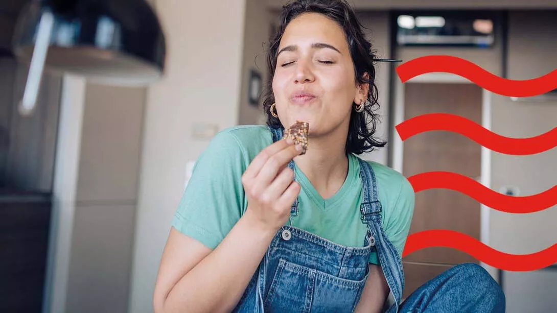 A woman eating cookies in her kitchen