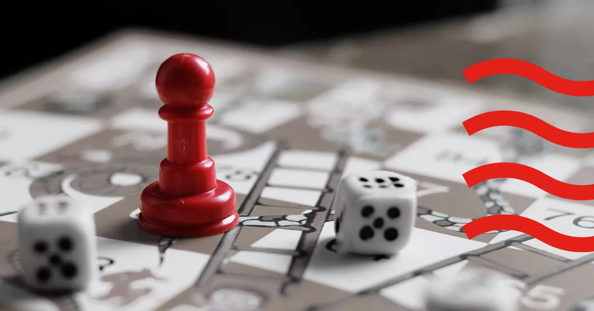 A red chess piece on a board with dices