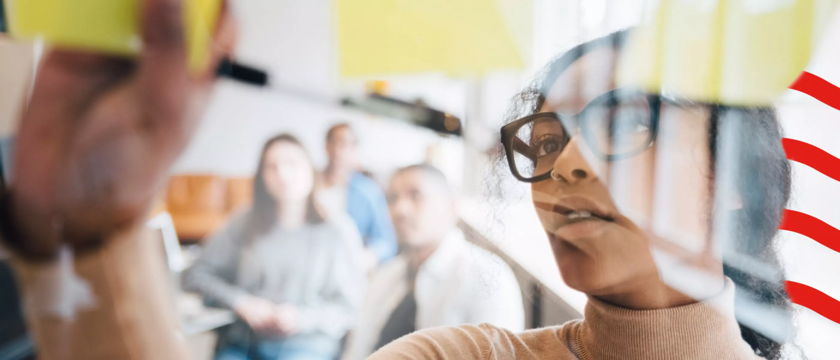 lady with glasses writing on post-it notes on wall